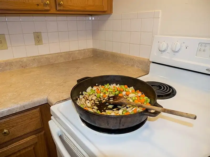 onion, celery and carrot sautéing in the deep ovenproof braiser, just lightly browning, some pieces still pale, spoon marks through to the pan